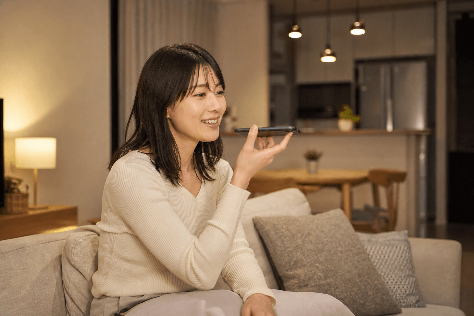 自宅でスマートフォンを使い、自然な距離で声に出して練習する女性の管理職